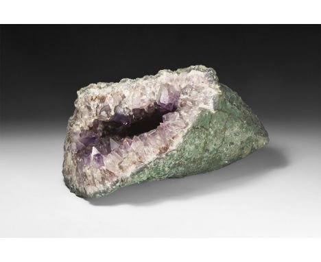 A large cut geode half with large cavity filled with white and pale purple crystals.  7.56kg, 27cm (10 1/2"). From a historic