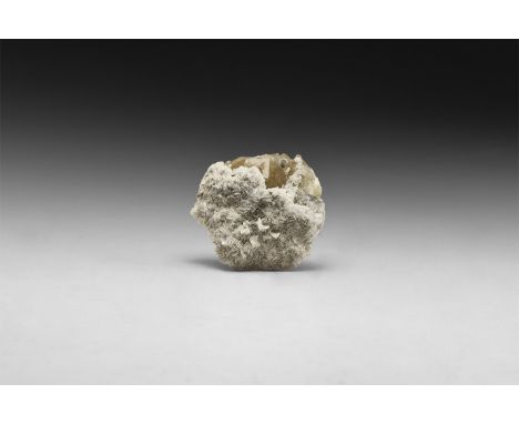 A fine specimen of dark yellow crystals of fluorite partially covered with white calcite layer, in white card tray with label