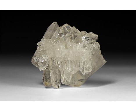 A fine formation of transparent quartz crystals, in white card tray with label reading: 'Quartz, Corinto, Minas Gerais, Brazi