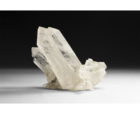 A fine formation of transparent quartz crystals, in white card tray with label reading: 'Quartz, Corinto, Minas Gerais, Brazi