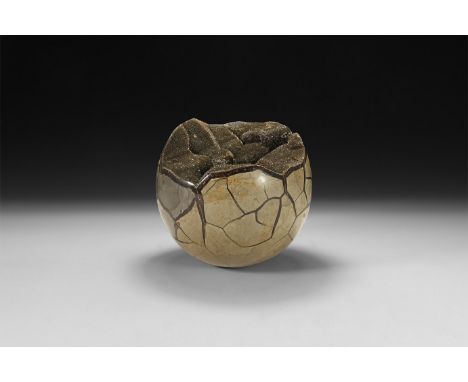 A large polished septarian egg with section cut to reveal internal cavity filled with clusters of small black crystals.  4.4 