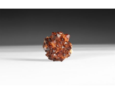 A fine specimen of dark orange citrine crystals on a matrix, in white card tray with label reading: 'Citrine, Rio Grande do S