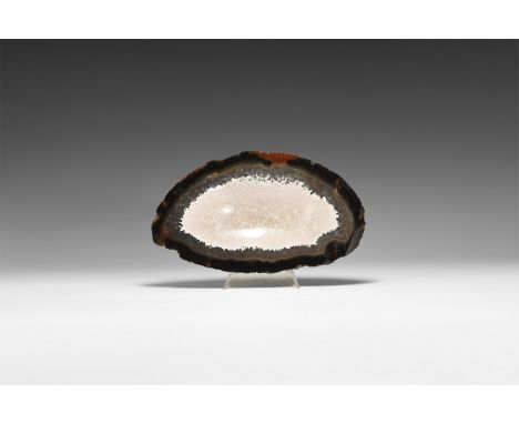 A very finely cut and polished agate slice with blue and red bands, centre cut with an elliptical bowl shape filled with pale