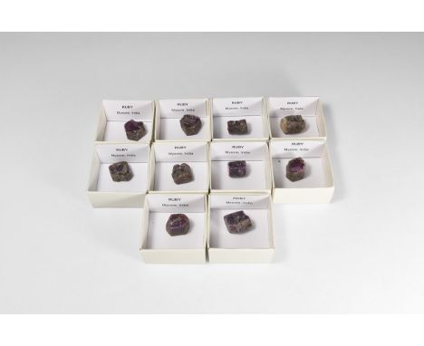 A group of ten dark purple hexagonal ruby crystals, from Mysore, India; each in a card tray.  192 grams total, crystals: 19-2