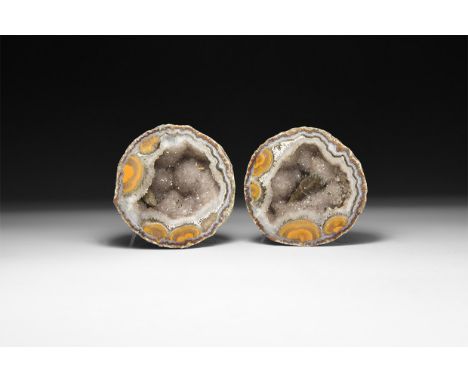 Two sawn and polished halves of an amethyst-lined agate geode, each with finely banded agate and pale purple amethyst crystal