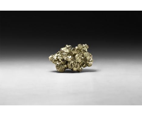 A group of fine lustrous pyrite crystals formed principally as striated pyritohedrons, in white card tray with label reading 