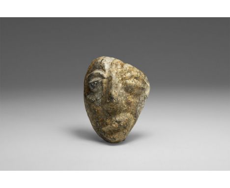 Pliocene Period, 5.2 - 2.5 million years BP. A mastodon fossil bone carving from the island of Java, a carved face.  105 gram
