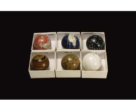 A group of cut and polished spheres of howlite, unakite, snowflake obsidian, brecciated jasper, tiger iron and sodalite; each