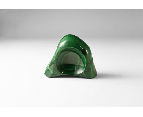 A cut and polished malachite with a carved 'bowl' to one side showing bands of dark green shades.  523 grams, 70mm (2 3/4"). 