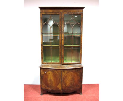 An Edwardian Flame Mahogany Book Cabinet, with stepped pediment, twin astragal glazed doors, adjustable shelves, over bow fro