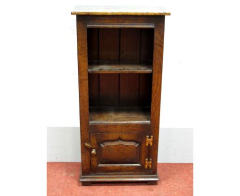 A Titchmarsh &amp; Goodwin Style Miniature Bookcase, with a single shelf, panelled door, on stile feet, 97cm high, 46cm wide.