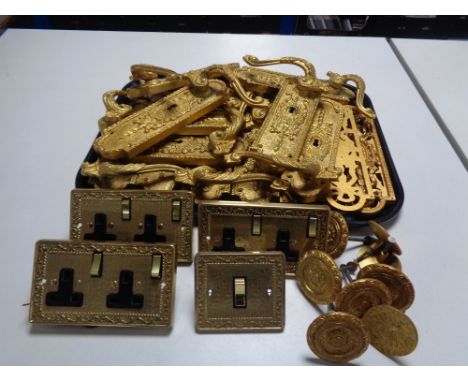 A tray of gilt metal door handles and finger plates, together with similar light switch and socket covers 