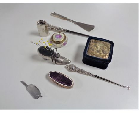 A box of two silver handled button hooks, silver handled shoe horn, pin cushion in the form of a shoe, pill boxes, miniature 