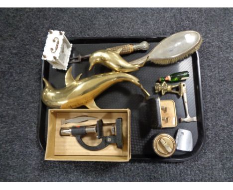 A tray containing a boxed Student microscope, brass figure of dolphins, plated backed hairbrush, miniature bottle of champagn
