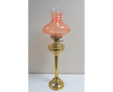 A 19th century brass oil lamp with pink glass shade and chimney, height 71 cm 
