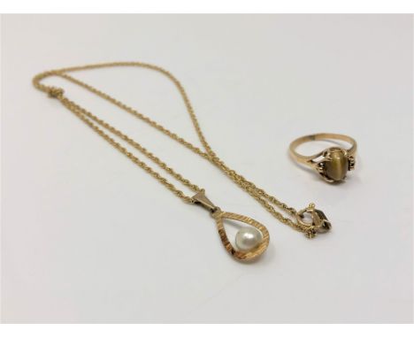 A gold pearl pendant on chain and a gold tiger's eye set ring (2)