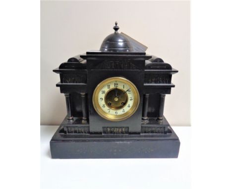 A 19th century German black slate half hour striking mantel clock with brass and enamel dial and key