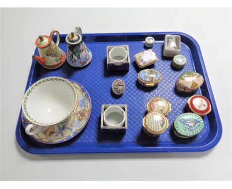 A tray containing miscellaneous items to include Halcyon Days enamel pill and trinket boxes, boxed Wedgwood napkin rings, Roy
