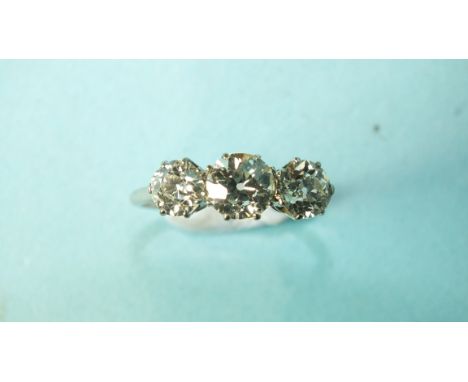 A three-stone diamond ring, the old brilliant-cut diamonds claw-set in platinum, (marks rubbed), total diamond weight approxi