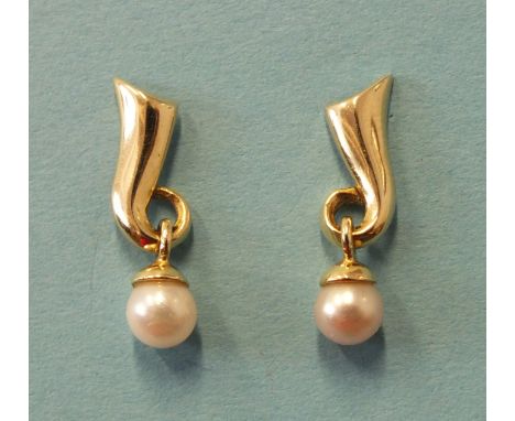 A pair of pearl drop earrings, the unmarked yellow gold scroll mounts with pearl drop below, (tests as 14ct).