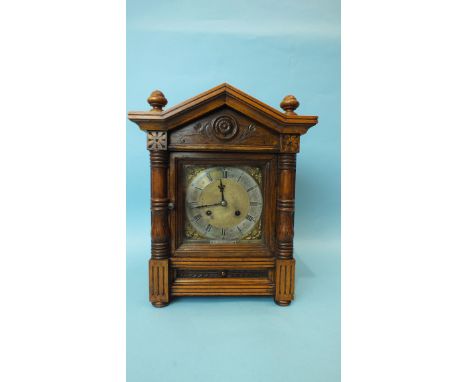 An Edwardian walnut mantel clock of architectural form, the dial with silvered chapter ring and gong-striking movement, signe