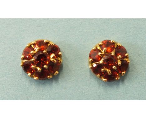 A pair of garnet cluster ear studs, claw set seven round cut garnets in 9ct gold mounts, 10mm diameter, 2.1g and a small pair