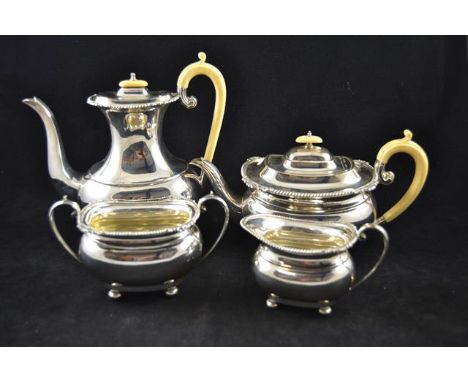 An early 20th century four piece silver tea set comprising teapot, hot water jug, sugar bowl & milk jug, ivory handles, gadro