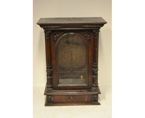 A late 19th century walnut cased 'penny in the slot' upright polyphon, the glazed door printed with 'The New Polyphon Supply 