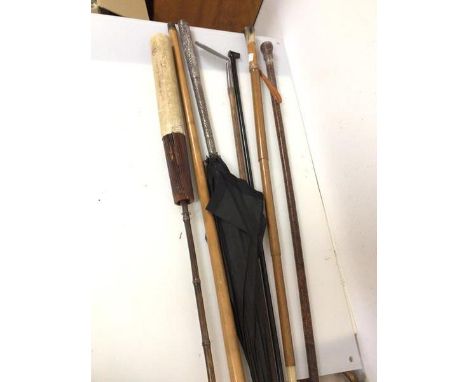 A collection of sticks, umbrellas and golf club, including a stick with leather exterior and silver cap, a collapsable cane w