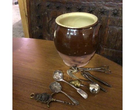 An earthenware jar with glazed interior and exterior, with shaped handles to side and two novelty corkscrews, nutcracker, lad