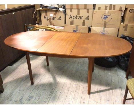 A mid century teak dining table, the tablet shaped top with magic leaf extension, on straight turned supports (74cm x 198cm e