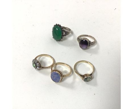 A collection of rings including three 9ct gold rings, including a cluster ring with central green stone surrounded by clear s