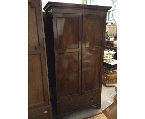 A late 19thc mahogany wardrobe, the moulded cornice above two panel doors enclosing a hanging rail and hooks to interior abov