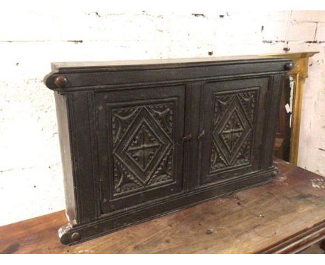 A 1920s Tudor style wall cabinet with two panelled doors enclosing a single shelf to interior (50cm x 88cm x 18cm)