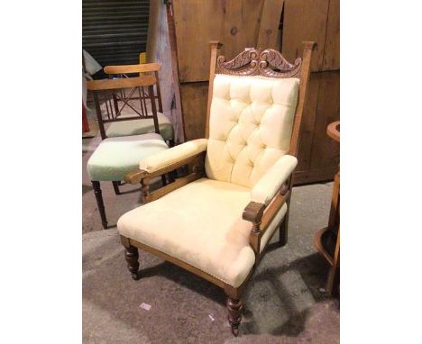A late 19thc/early 20thc armchair, with moulded crest above a button back and upholstered arms and seat, in cream upholstery,