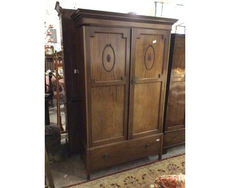An early 20thc mahogany Georgian inspired wardrobe, the moulded cornice above two panel doors enclosing a hanging rail and ho