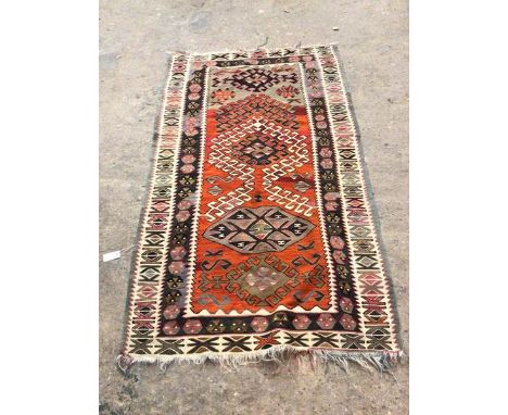 A kelim rug, the central panel with burnt orange and grey field, with abstract design within two borders of geometric pattern