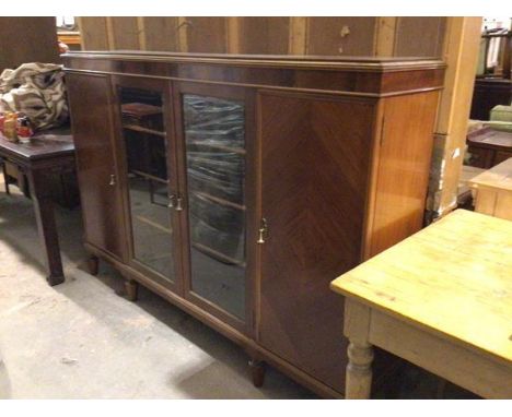 A 1950s figured mahogany bookcase, the rectangular top with moulded edge and plain frieze above a pair of central glazed astr
