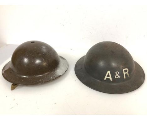 Two helmets of WWII vintage, each bearing the intials A &amp; R one having been later painted (13cm x 28cm x 31cm)