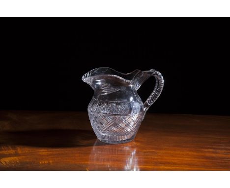 A 19TH CENTURY CUT GLASS JUG, of baluster form with diamond fold banding, and c-scroll handle. 17cm tall x 21cm wide over han