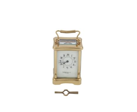 AN EDWARDIAN BRASS CASED CARRIAGE CLOCK, of compact proportions, with French movement, the face of delicately painted enamel 