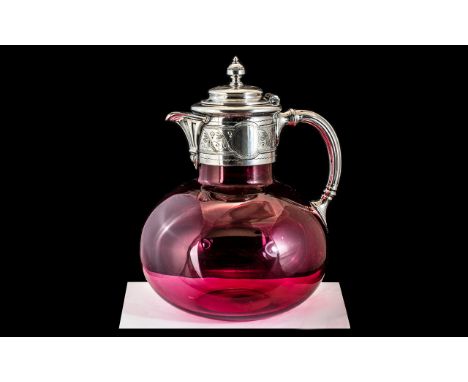 A Victorian Cranberry Glass Decanter silver plated spout and handle. Height 8 inches.