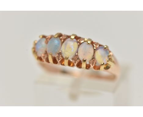 A LATE VICTORIAN 15CT GOLD OPAL RING, designed as a row of five oval cut opals, each claw set to a polished band, hallmarked 