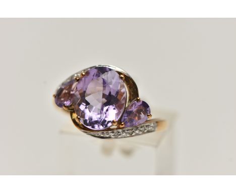 AN AMETHYST AND DIAMOND RING, designed as an oval amethyst flanked by pear shape amethysts to the crossover band set with sin
