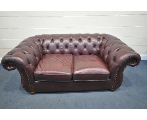 A LATE 20TH CENTURY BURGUNDY LEATHER TWO SEATER CHESTERFIELD SOFA, length 192cm x depth 105cm x height 72cm (condition report