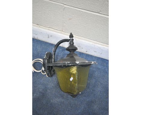 AN EARLY TO MID 20TH CENTURY WROUGHT IRON WALL MOUNTED LANTERN, with a tapered yellow glass shade (condition report: -some pa