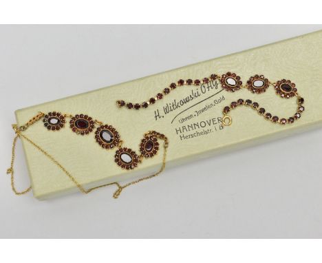 A YELLOW METAL GARNET NECKLACE AND A BRACELET, the necklace fitted with five oval garnet cluster links (one small garnet is m