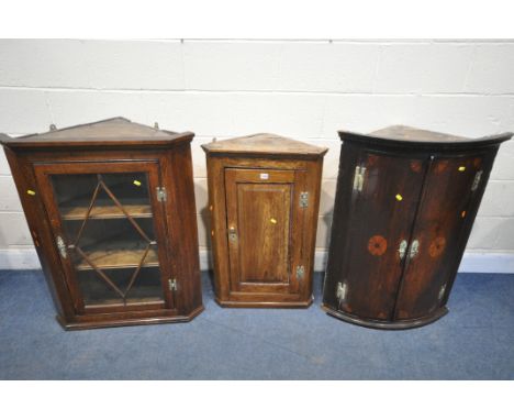 THREE VARIOUS GEORGIAN OAK CORNER CUPBOARD, including a bowfront two door cabinet, a small fielded panel cupboard, and a glas