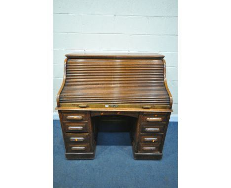 AN EARLY 20TH CENTURY OAK ROLL TOP DESK, containing an arrangement of drawers and shelves, over two pedestals with four drawe