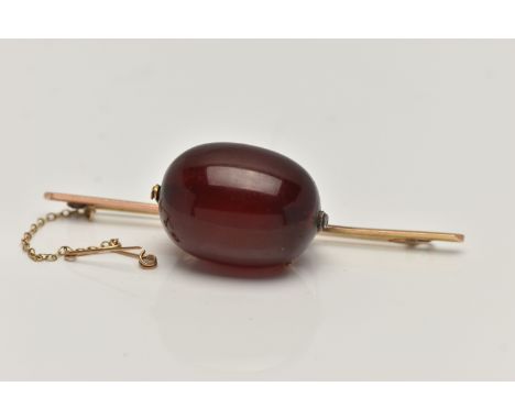 A CHERRY BAKELITE BEAD BROOCH, a large single, oval bead measuring approximately length 28.1mm x width 21.6mm, claw mounted o